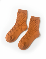 Pair of brown socks with textured pattern on a white background