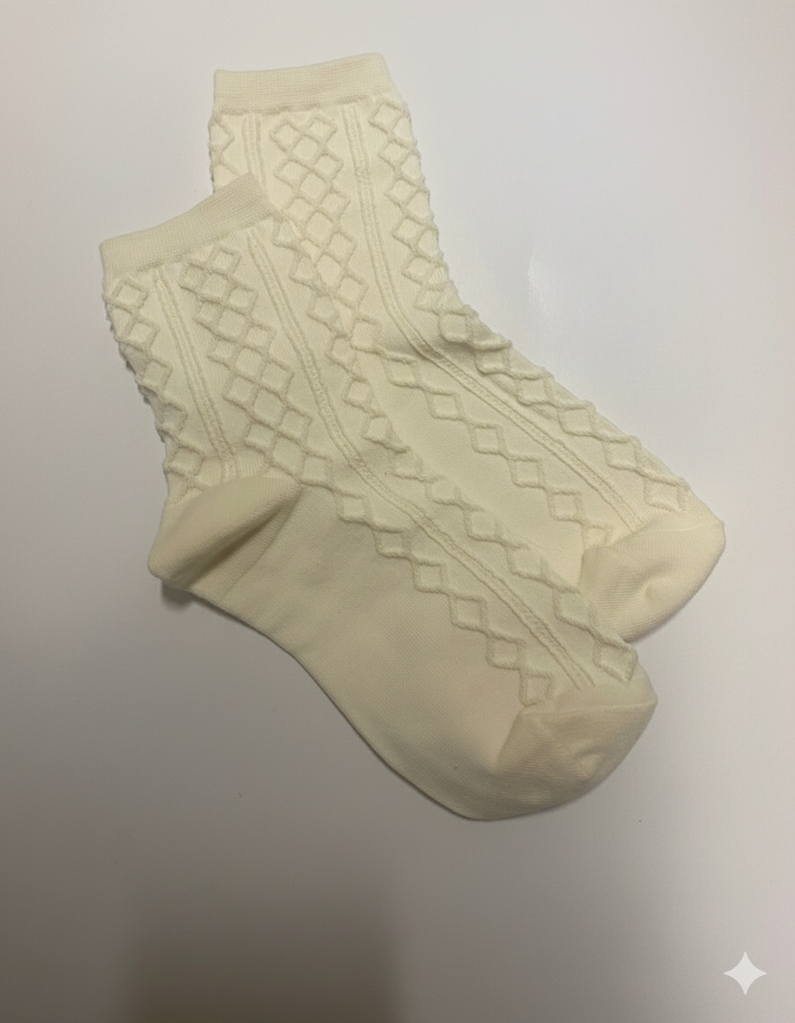 Pair of beige socks with textured pattern on a light gray background