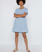 Woman wearing a light blue dress with floral pattern on a white background