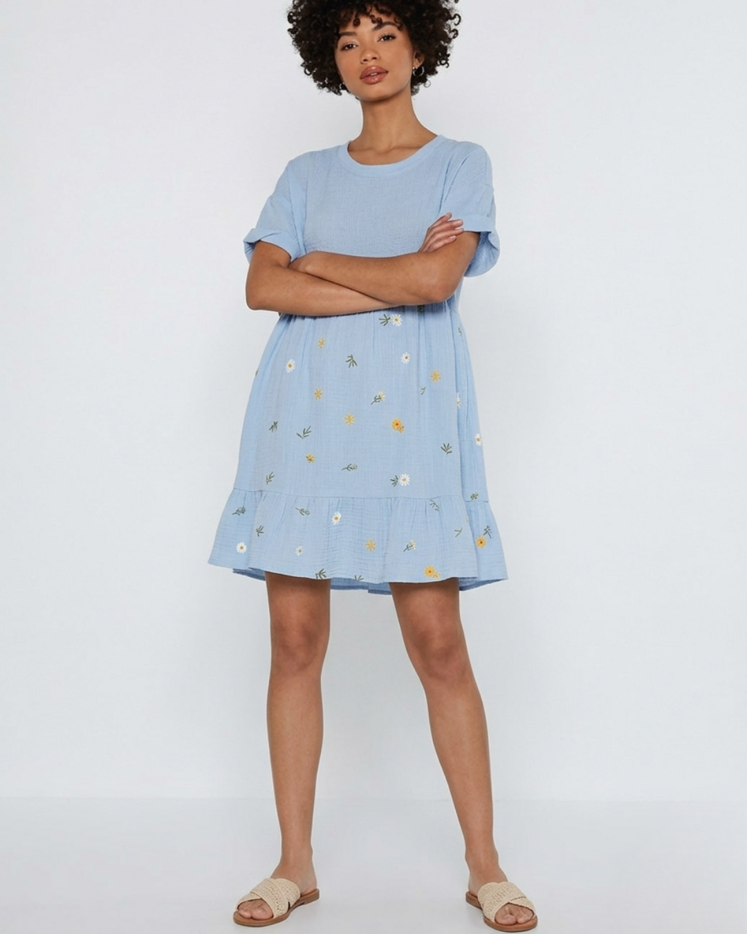 Woman wearing a light blue dress with floral pattern on a white background