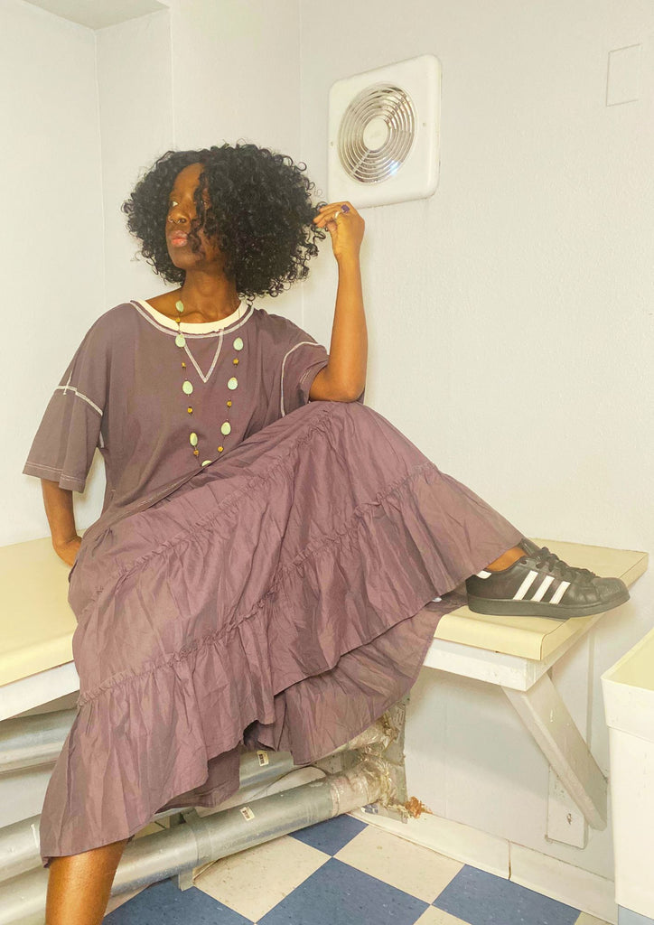 Tiered charcoal tee-dress maxi, relaxed silhouette with contrast seams; styled with Adidas sneakers