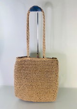 the back of the khaki woven crochet tote bag - long braided straps – fun and practical bag for vacation looks, gifting, or daily errands