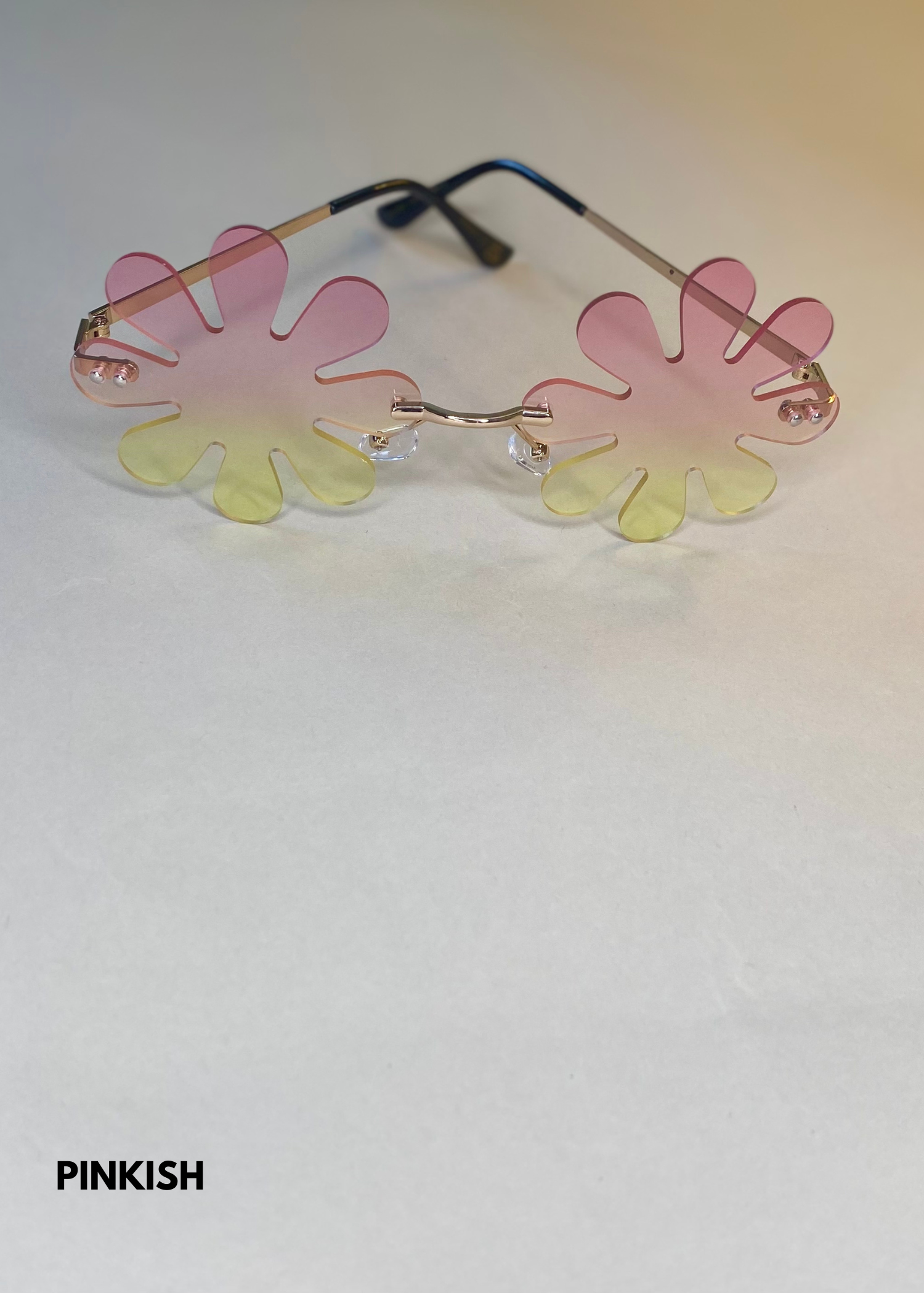 pink gradient splat sunglasses in a daisy flower shape - stylish rimless sunnies with playful petal design and gold temples