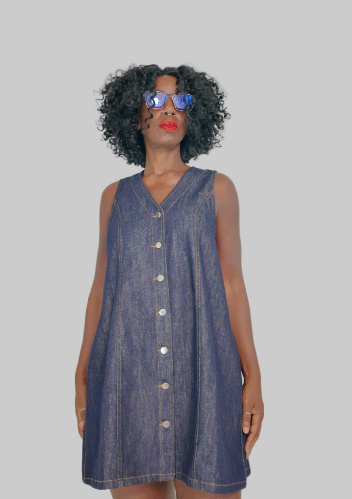 Model in short button-front denim A-line dress in dark indigo with contrast stitching